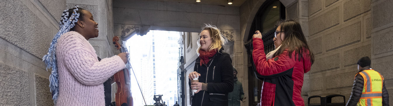 students film a performer in Philadelphia. 